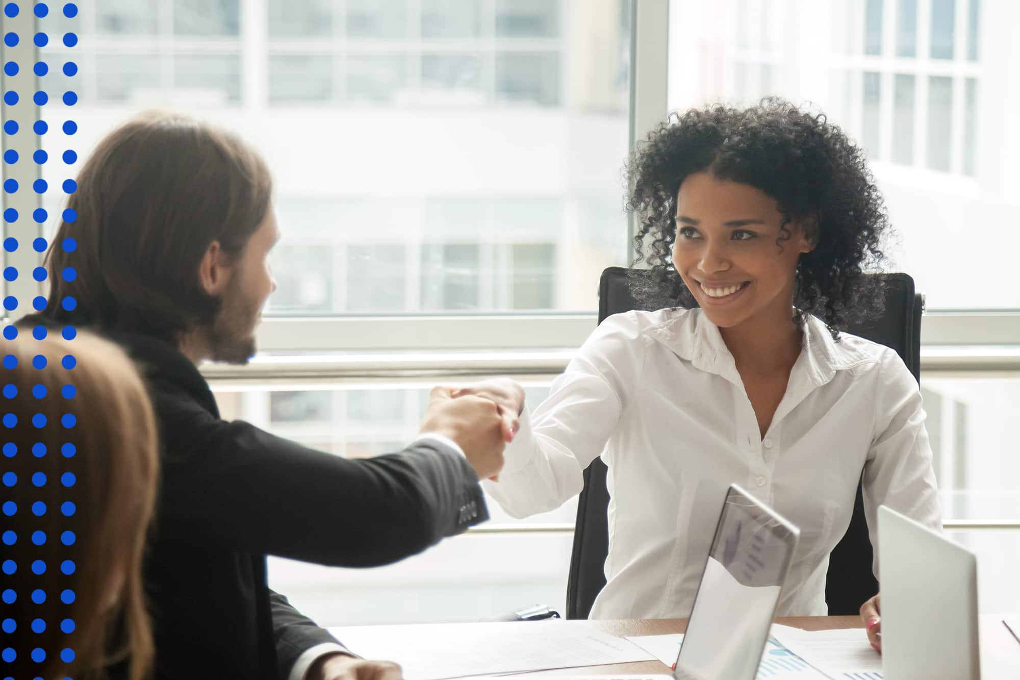 Smiling partners shaking hands