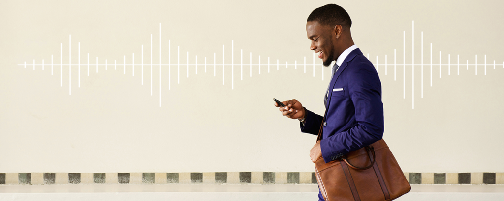 Man walking down street while looking at smart phone