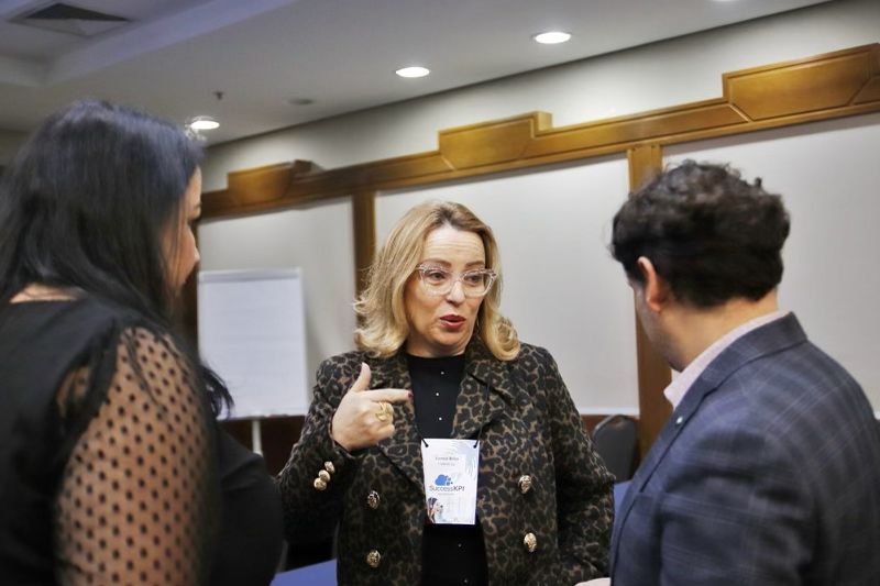 Conference attendee speaking with two participants during a business discussion